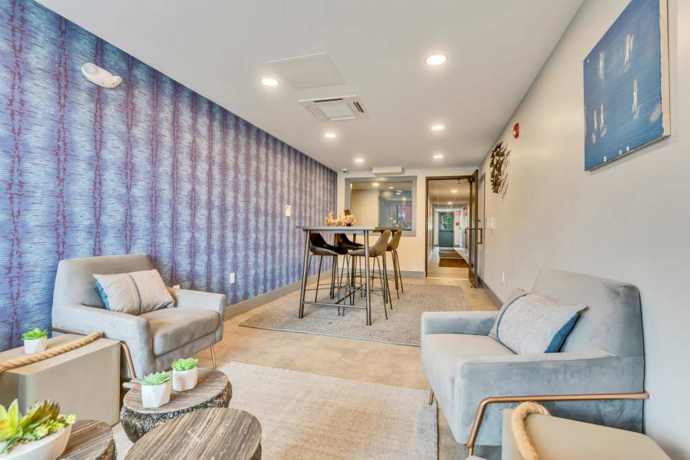 Seating area with gray chairs and table at Latitude at South Portland in Portland, Maine
