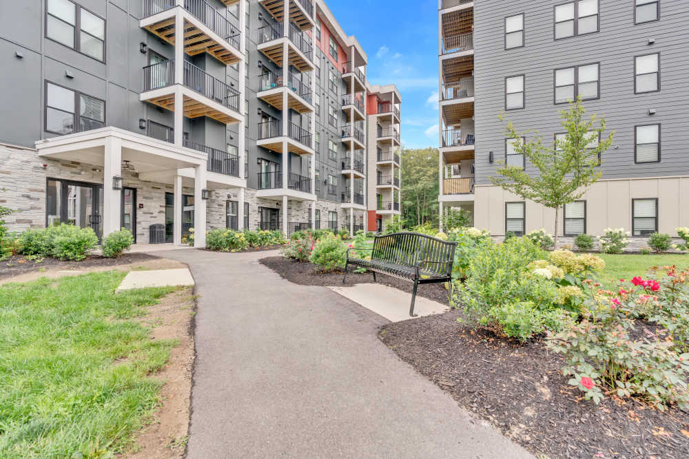 Gray building with balconies and landscaped path at Latitude at South Portland in Portland, Maine