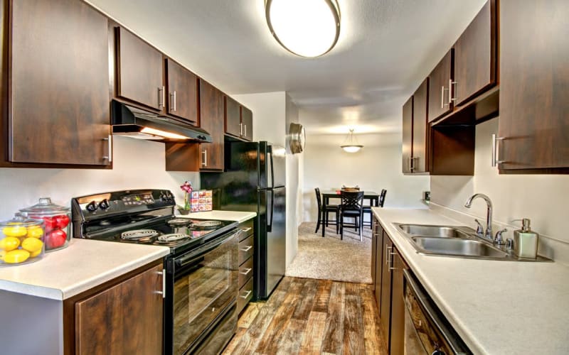 Renovated kitchen with brown cabinets at Wellington Apartment Homes in Silverdale, Washington