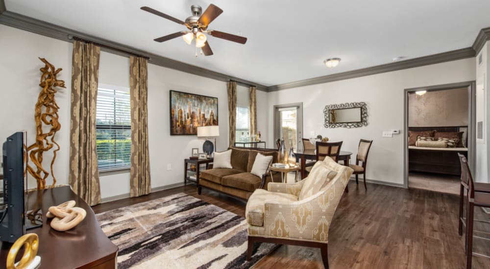 Couch and a comfortable chair in a model home's living space at Avenues at Tuscan Lakes in League City, Texas