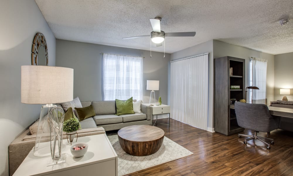 A furnished apartment living room and bar seating at the kitchen peninsula at Verandahs at Cliffside Apartments in Arlington, Texas