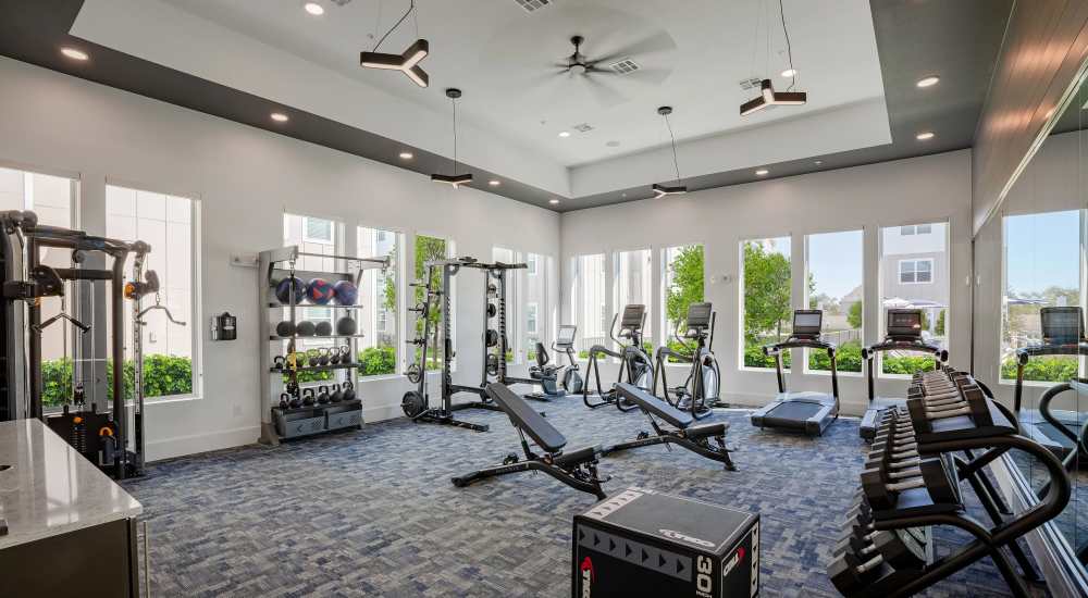 Fitness center with equipment at August Friendswood in Friendswood, Texas