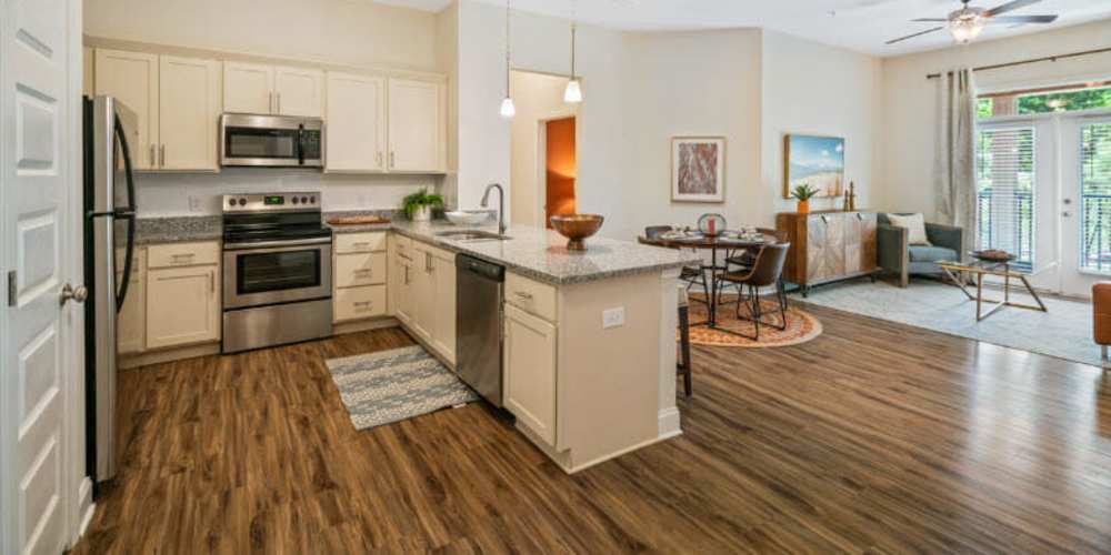 Fully equipped island kitchen with granite countertops stainless steel appliances like a refrigerator, stove, and drawer microwave at Lodge at Lake Wylie in Lake Wylie, South Carolina 