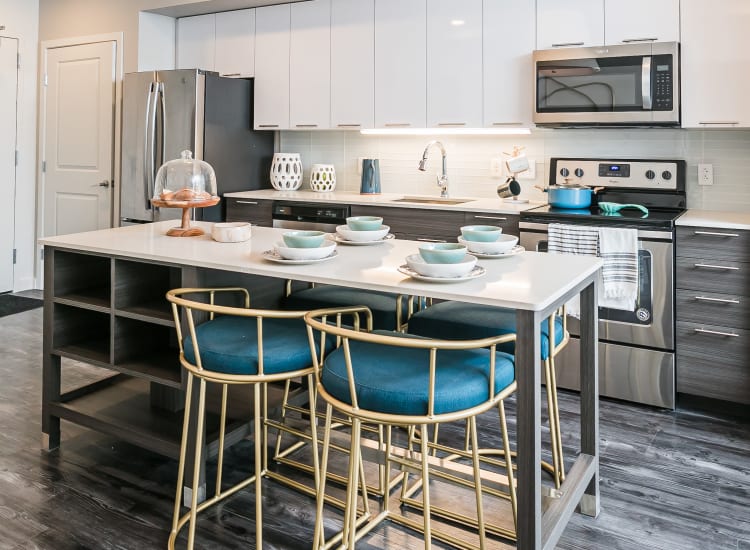 Stainless-steel appliances and custom cabinetry in a model home's kitchen at City Centre Ithaca in Ithaca, New York