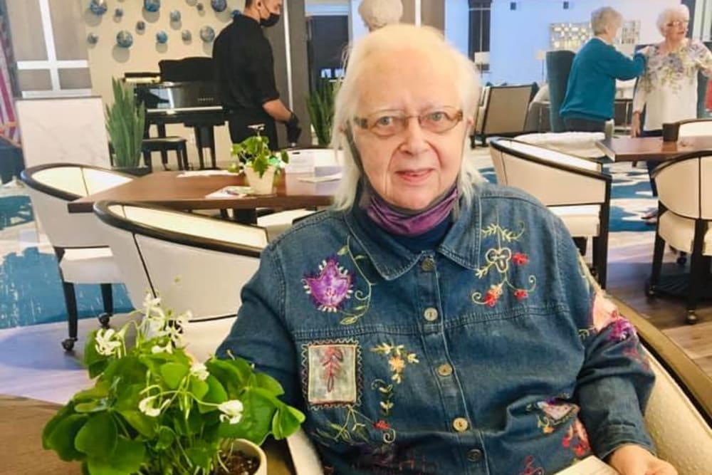 Resident taking a photo with her plant at Blossom Ridge in Oakland Charter Township, Michigan