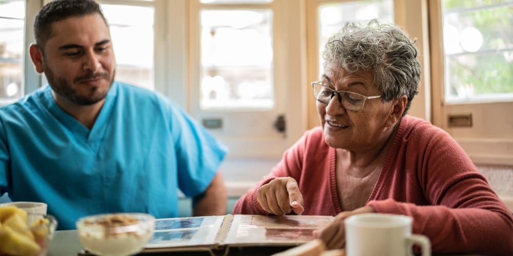 Resident looking through photos with a staff member at Barclay House of Aiken in Aiken, South Carolina