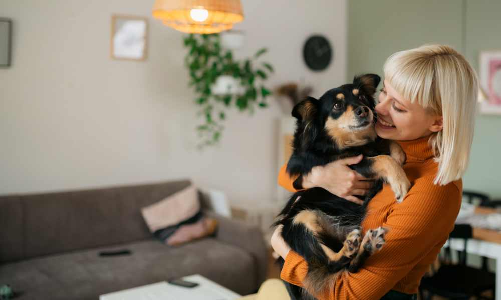 Resident woman holding her dog in her living room at Miller Landing in Cleveland, Tennessee