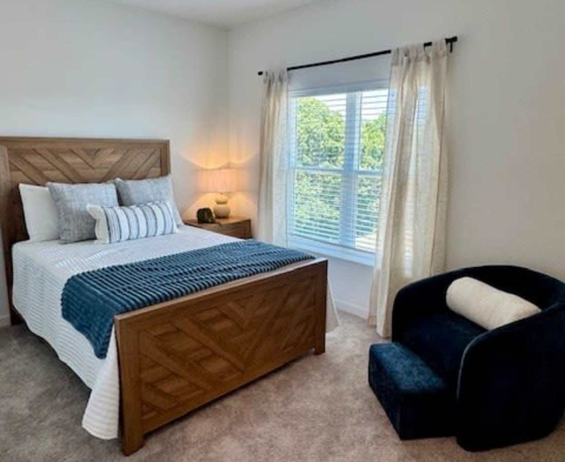Bed with blue throw blanket and pillows at Pritchard Park Place in Racine, Wisconsin