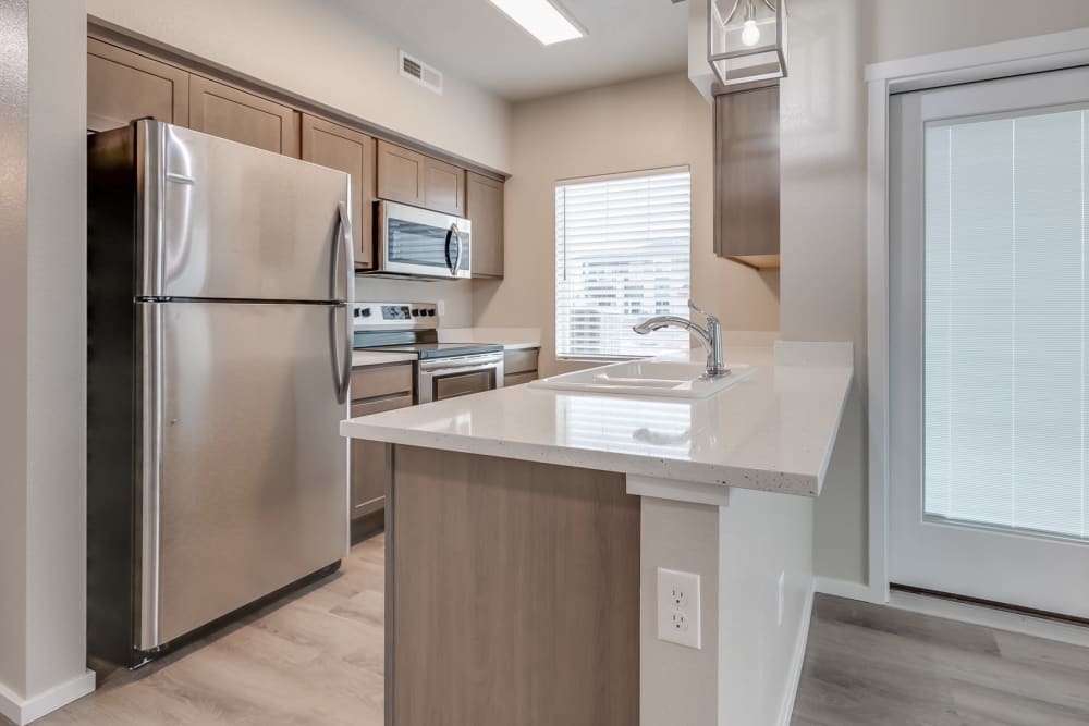 Fully-equipped modern kitchen with stainless steel appliances and high-end finishes at Olympus at Ten Mile in Meridian, Idaho