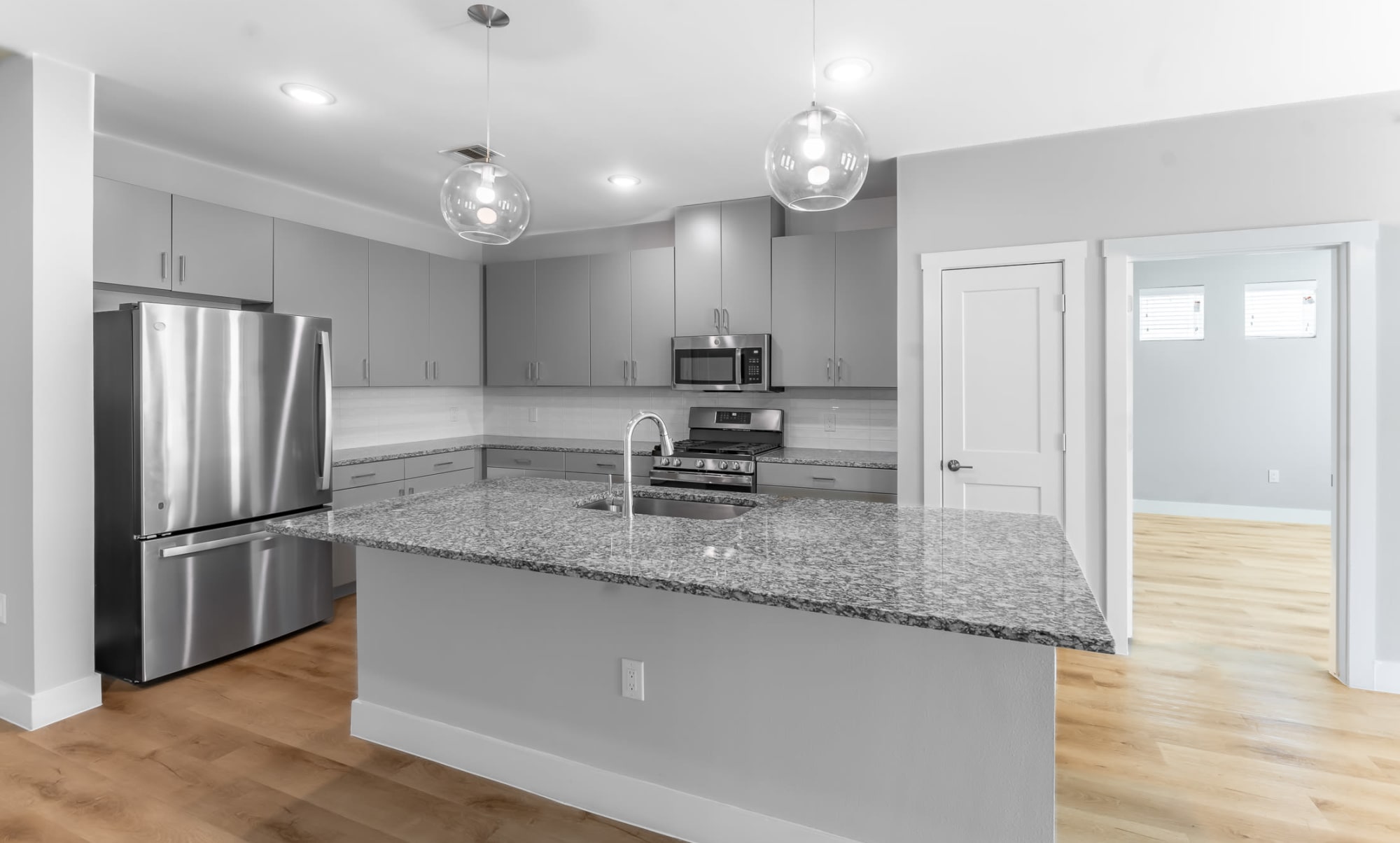 Luxury two bedroom with stainless steel applicance and wood style flooring at Floor Plans at The Gabriel in Leander, Texas