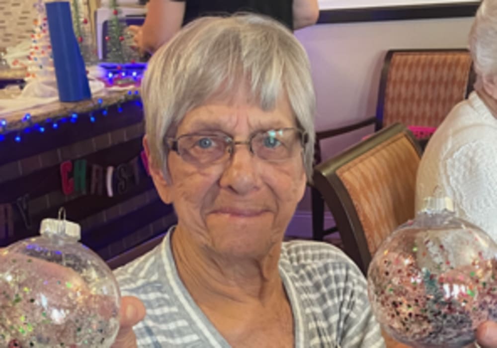 Resident with two snow globes at Truewood by Merrill, Keller in Keller, Texas