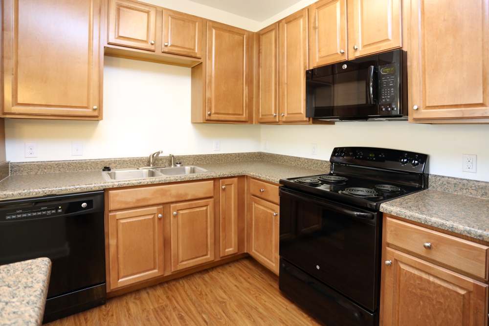 Modern kitchen with wooden cabinets at Adams Crossing Apartment Homes in Waldorf, Maryland