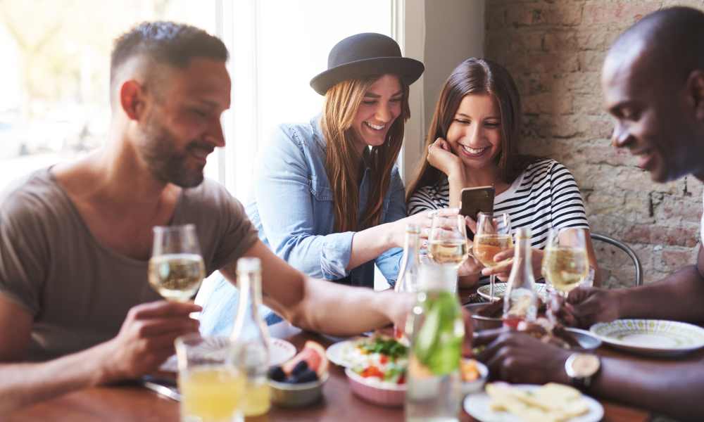 Residents sharing a meal together in a restaurant near Highland Pointe Apartments in Cottonwood Heights, Utah