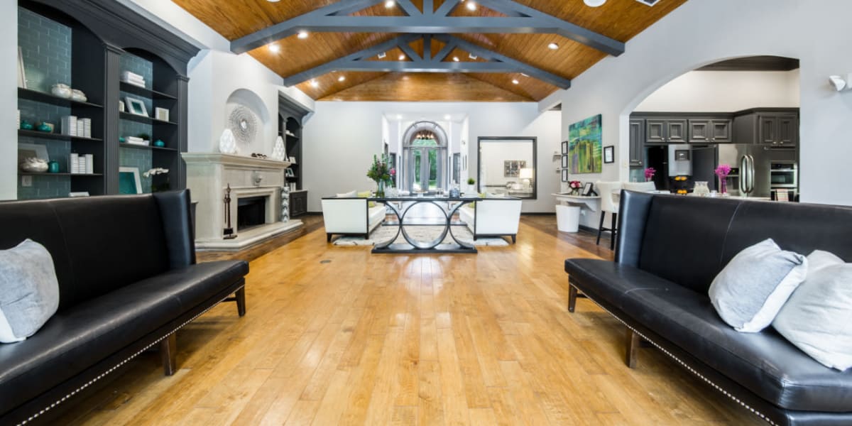 High back leather sitting loveseats in community clubhouse with wood flooring at Marquis at Kingwood in Kingwood, Texas