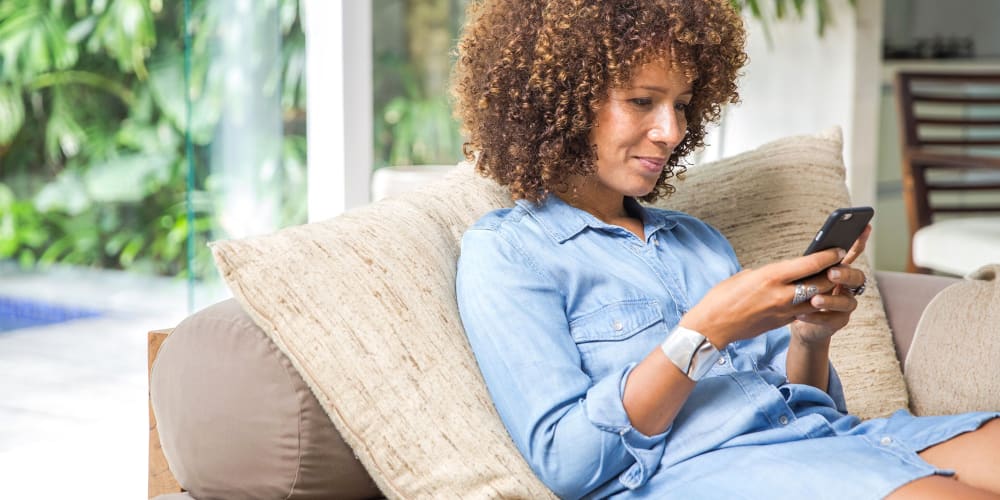 Resident checks out specials on her phone at Olea Beach Haven in Jacksonville, Florida