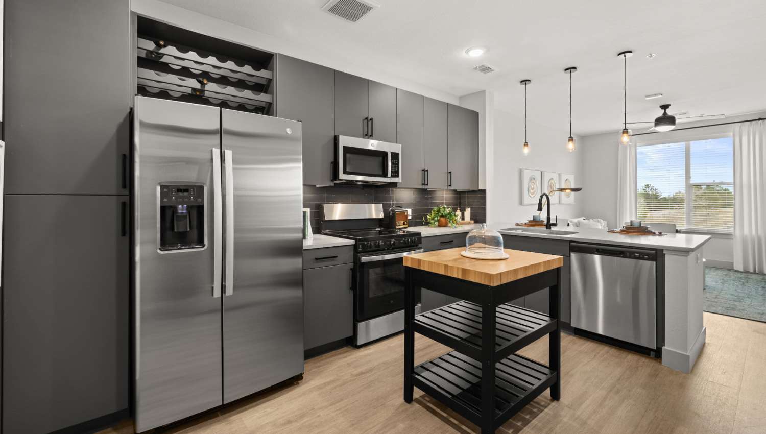 An apartment kitchen with stainless-steel appliances and side by side refrigerator at The Lock at Flatirons in Broomfield, Colorado