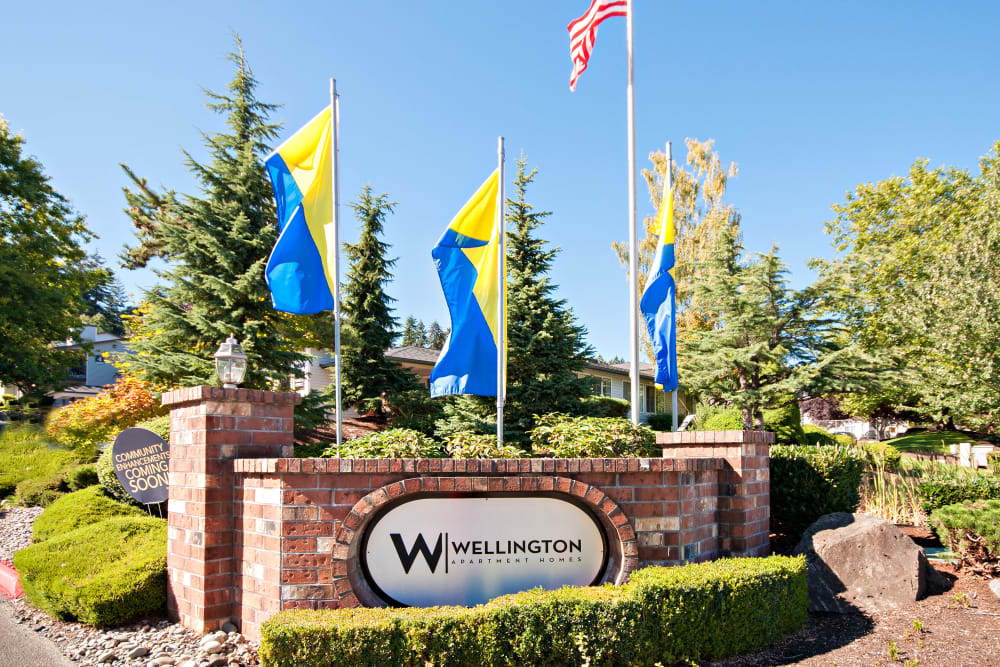 The monument sign and flags at the entrance of Wellington Apartment Homes in Silverdale, Washington