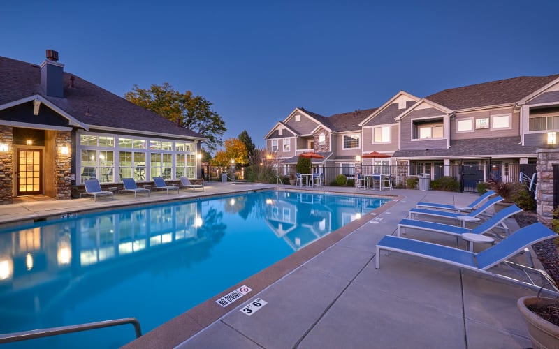 Fire pit lounge area poolside and pool at sunset at Crestone Apartments in Aurora, Colorado