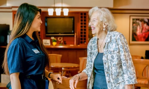 A resident and a staff member talking at a Merrill Gardens community.