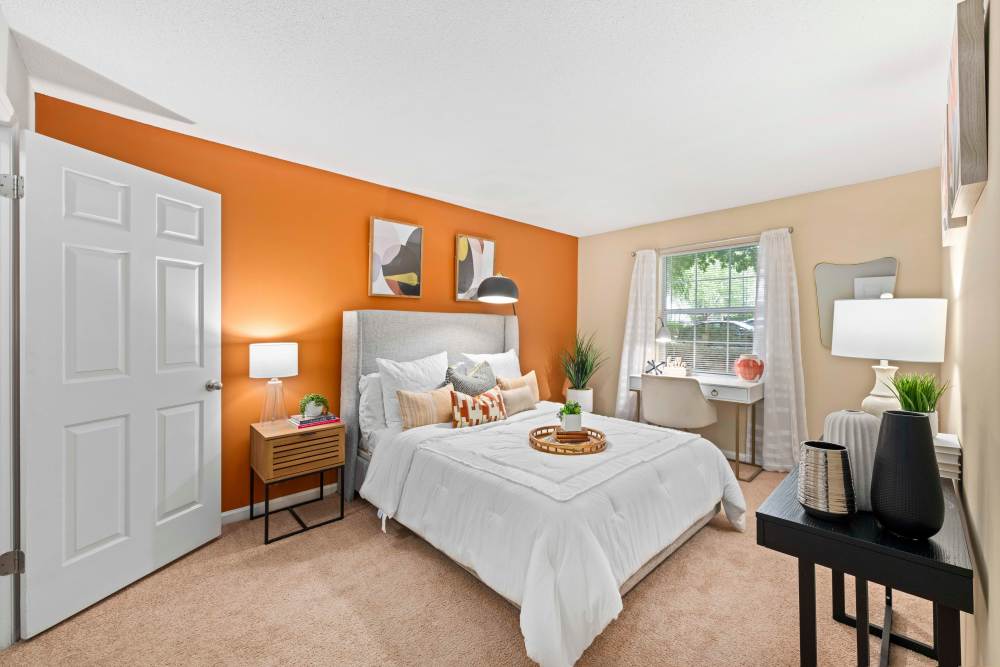 Spacious bedroom with large comfortable bed, desk, and large window at The Ellery of Cary in Cary, North Carolina