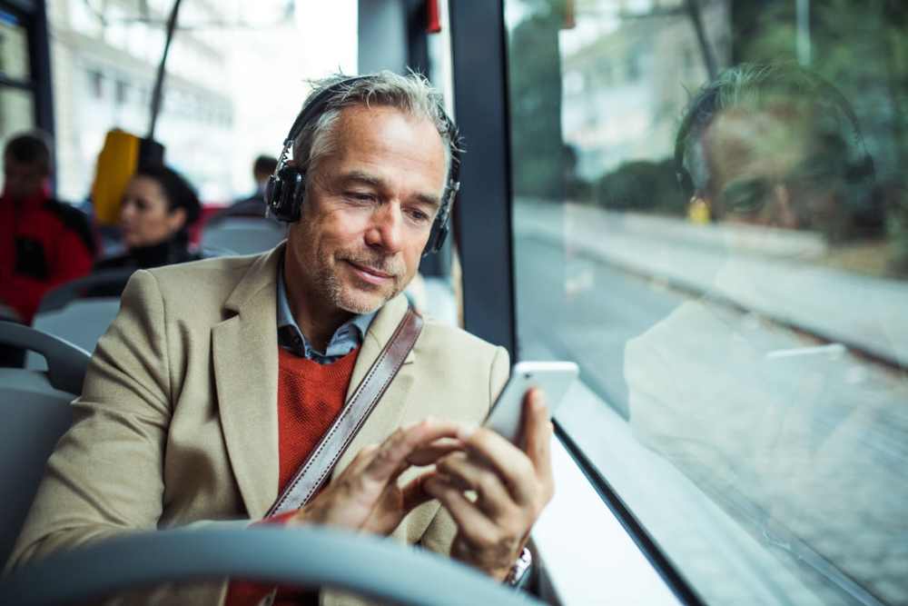 Man looking at phone on bus heading downtown not far from Brannigan Village in Winston Salem, North Carolina