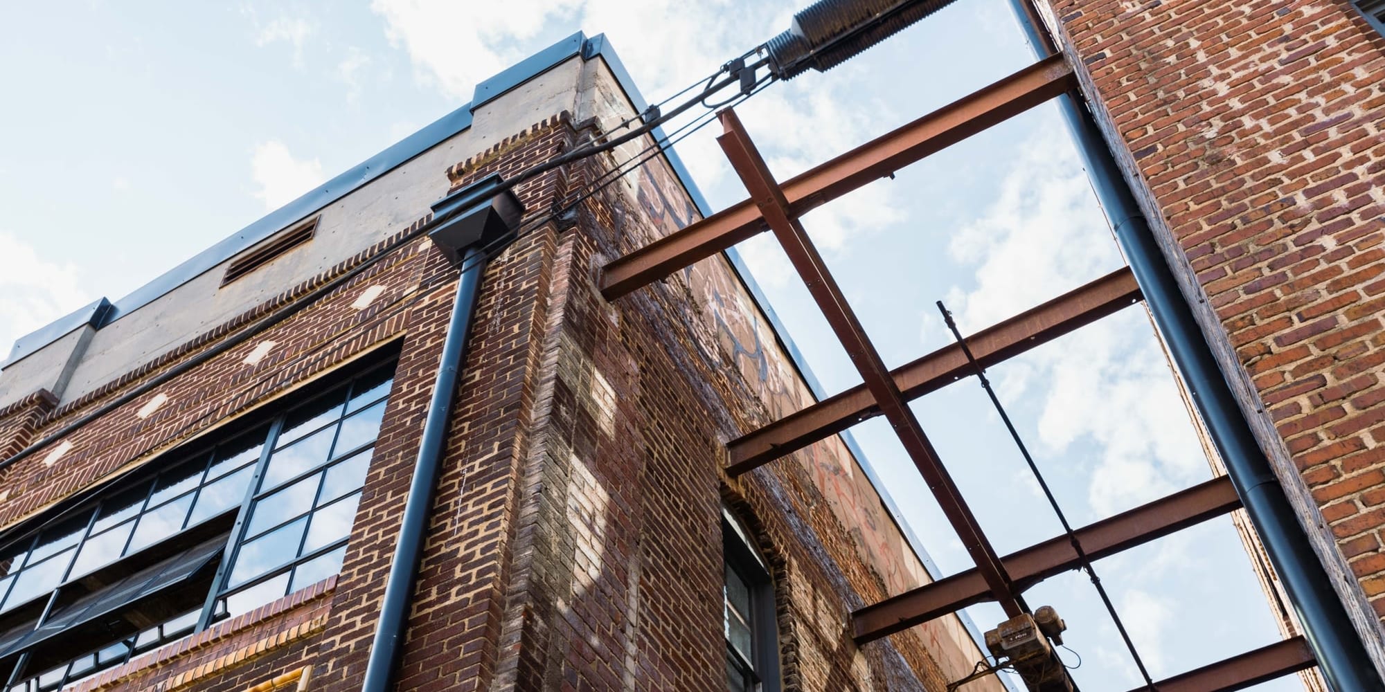 Exterior view with glass, brick and beams at Lofts at Abrams Fixtures in Atlanta, Georgia