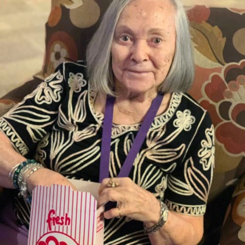 A happy resident eating popcorn at FountainBrook in Midwest City, Oklahoma