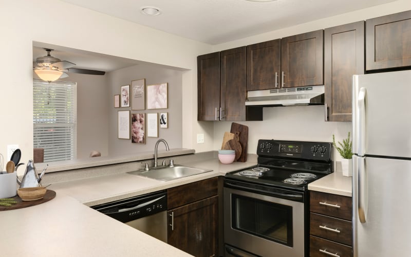 Fully equipped kitchen with brown cabinetry at Meadows at Cascade Park Apartments in Vancouver, Washington