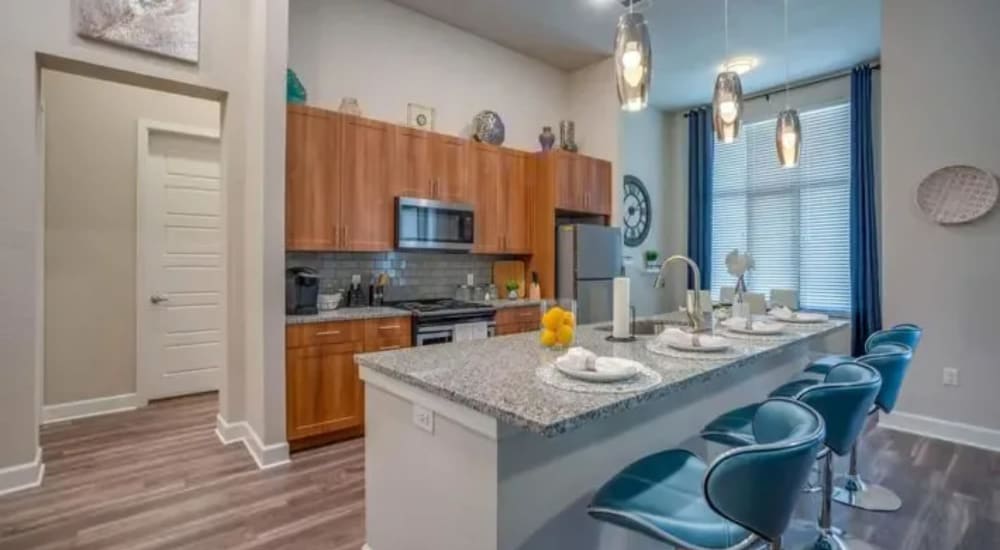 Kitchen with island and stainless-steel appliances at Luxia Craig Ranch, Mckinney, Texas