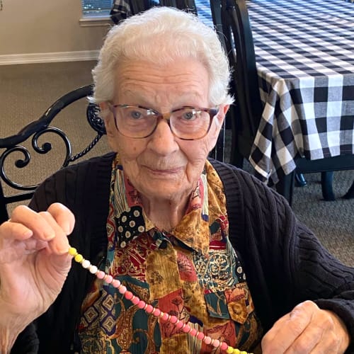 Resident holding a bead necklace at Canoe Brook Assisted Living in Ardmore, Oklahoma