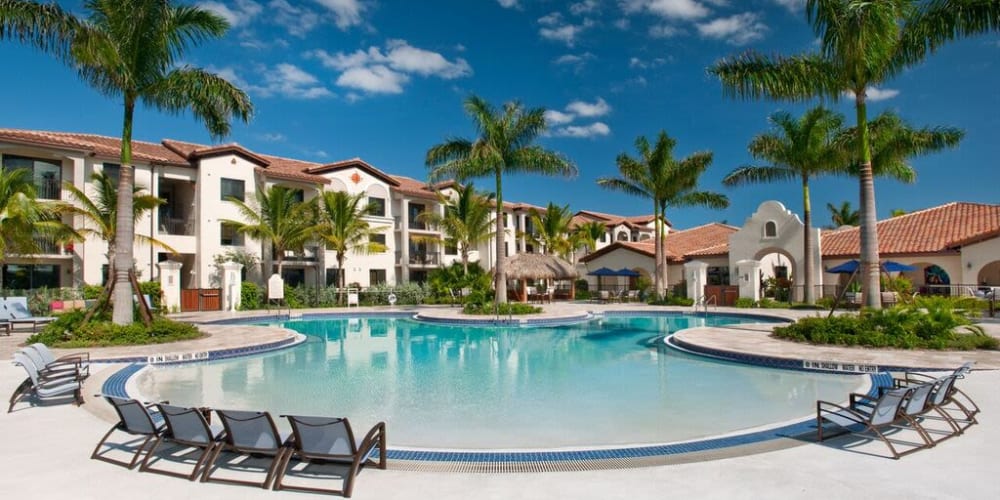 Swimming pool area with chaise lounge chairs on the sun deck at Doral View Apartments in Miami, Florida
