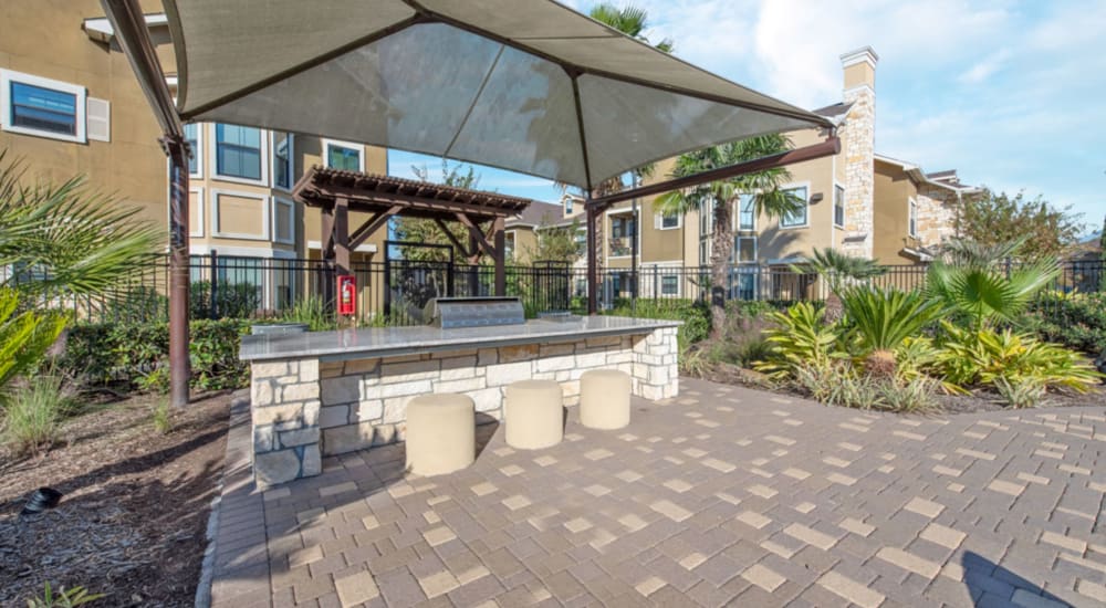 Covered Outdoor Kitchen with Dining Area & TV at Avenues at Tuscan Lakes in League City, Texas
