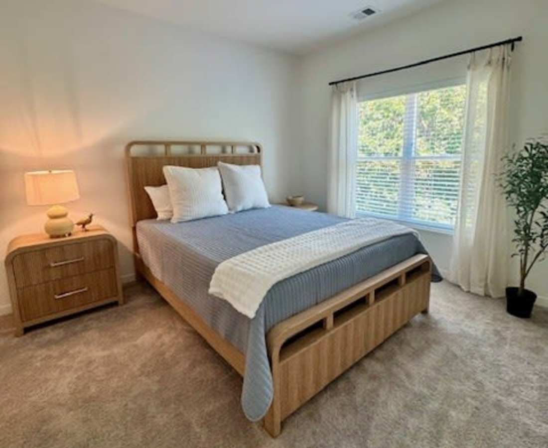 Bed with blue bedding and white pillows at Pritchard Park Place in Racine, Wisconsin