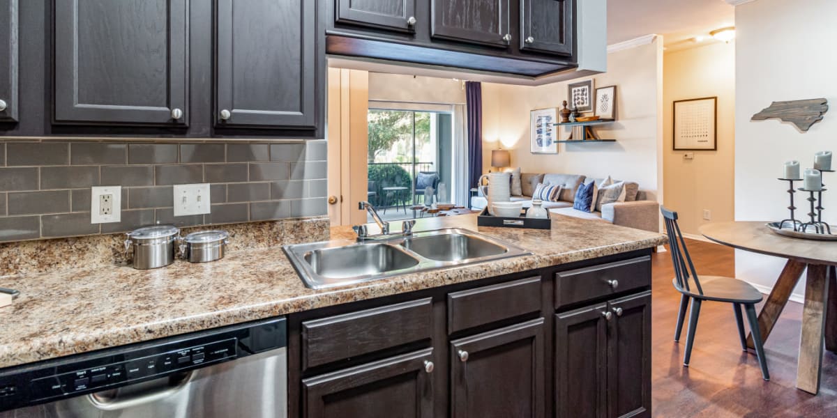 Modern style kitchen area with wood cabinets and flooring at Marquis of Carmel Valley in Charlotte, North Carolina