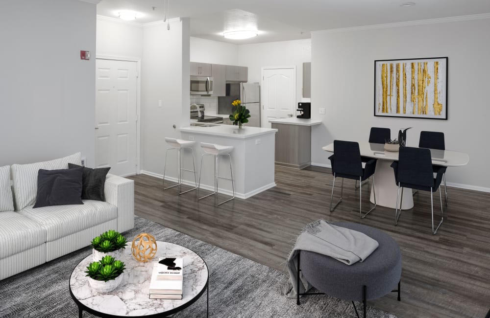 A fully furnished unit with a rug on top of hardwood floors, a couch, love seat and coffee table at The Grove at Orenco Station in Hillsboro, Oregon