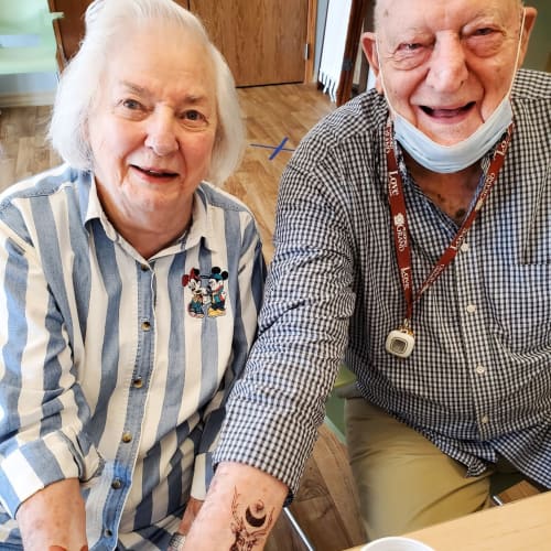 Resident couple showing off temporary tattoos at The Oxford Grand Assisted Living & Memory Care in Wichita, Kansas