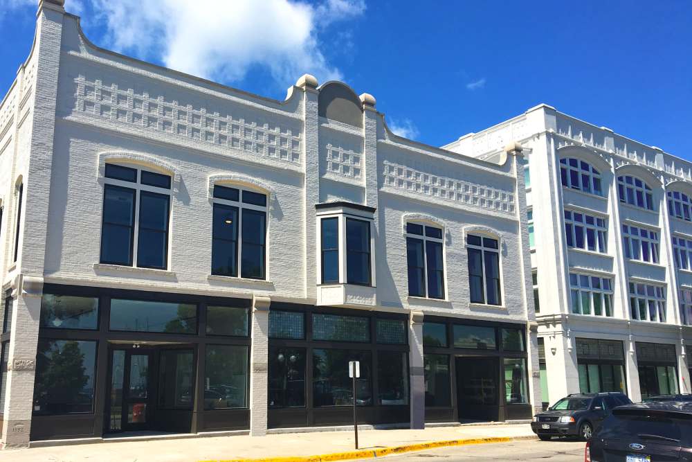 Historic brick buildings with large windows and modern design elements, inviting atmosphere and potential for vibrant community life at Lloyd House II in Menominee, Michigan