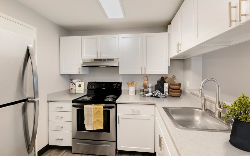 Renovated kitchen with white cabinets at Meadows at Cascade Park Apartments in Vancouver, Washington