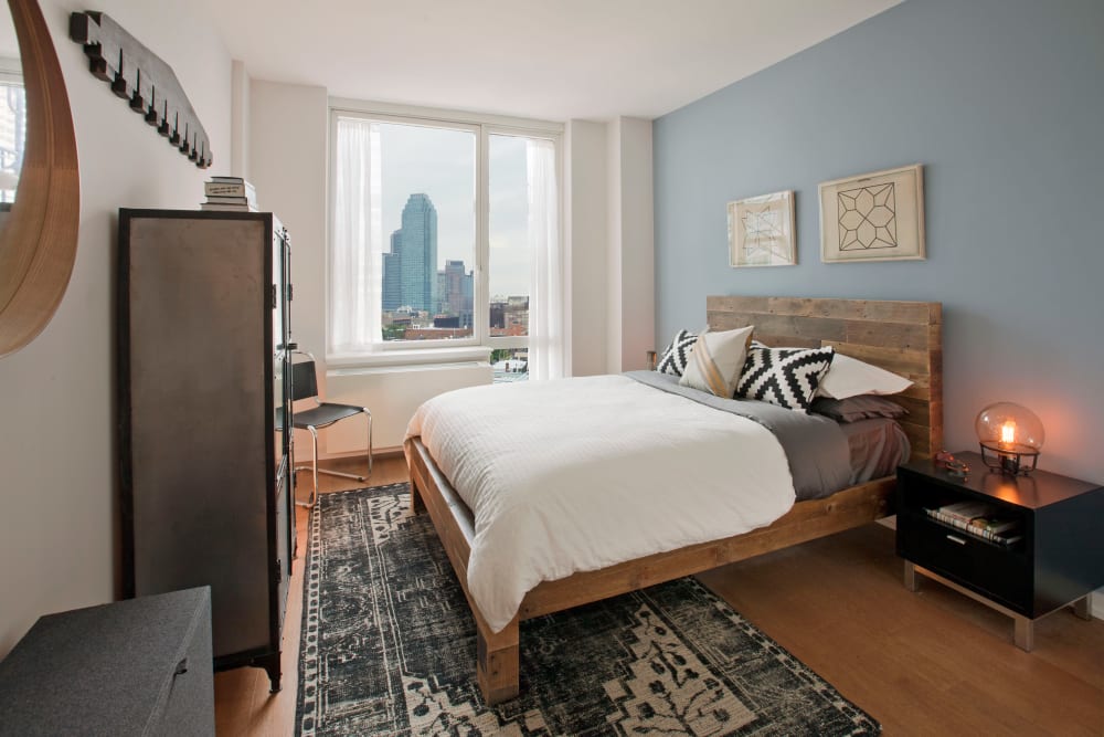 Modern bedroom decorated with tons of natural light at The Maximilian in Queens, New York