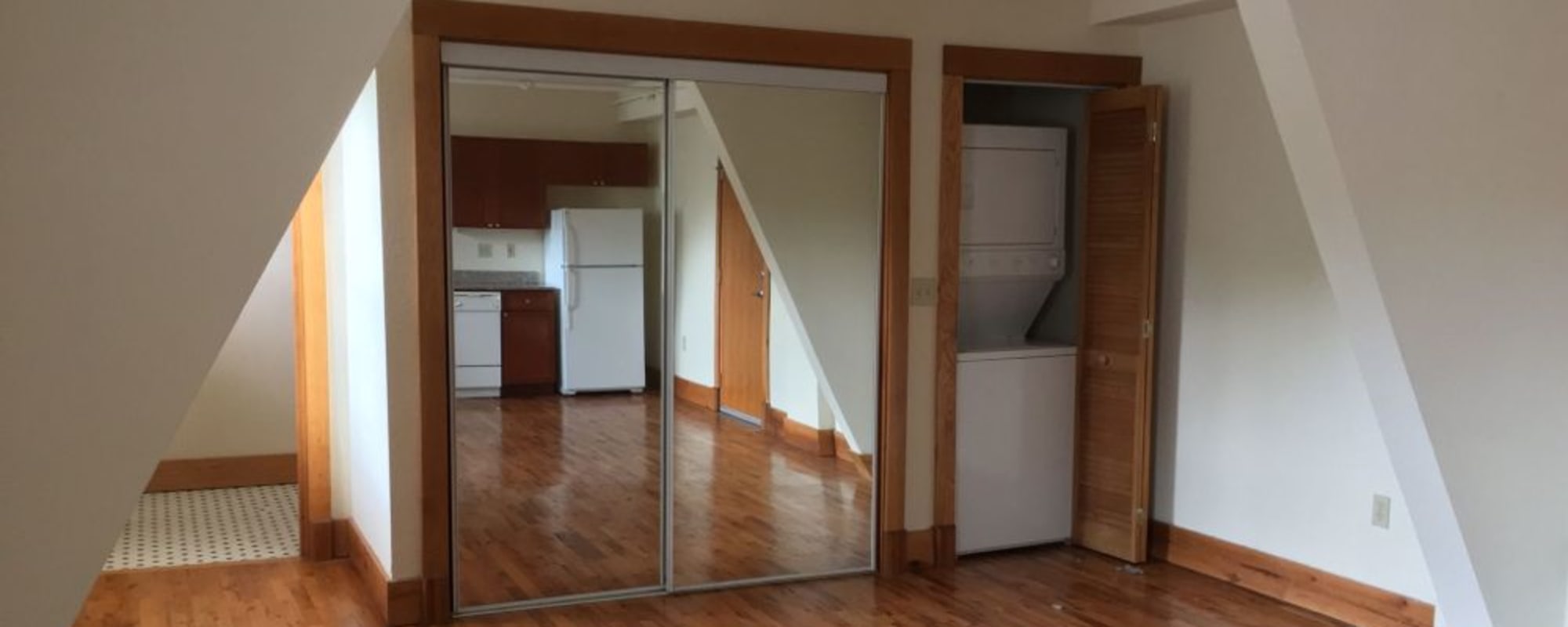 Mirrored closet doors next to a stacked washer and dryer in an apartment at Kenilworth Inn in Asheville, North Carolina