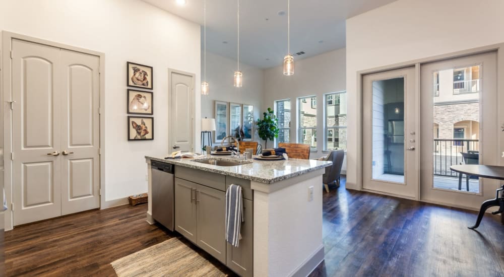 Kitchen with wood-style flooring and an island at Luxia Craig Ranch, Mckinney, Texas