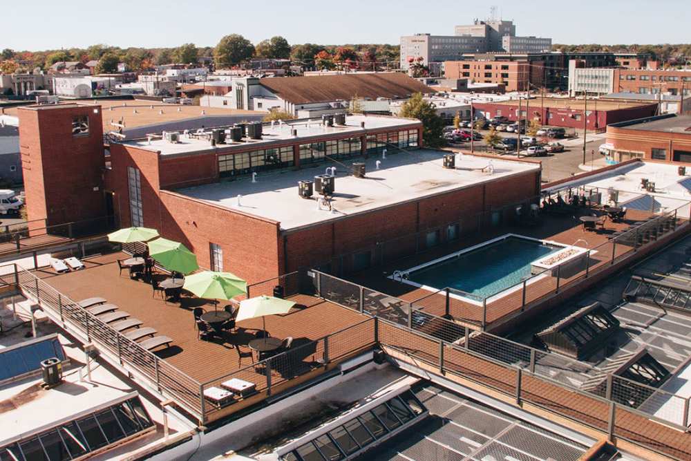 Rooftop pool with lounge chairs and umbrellas at Courtyard Lofts at Scott’s Addition in Richmond, Virginia