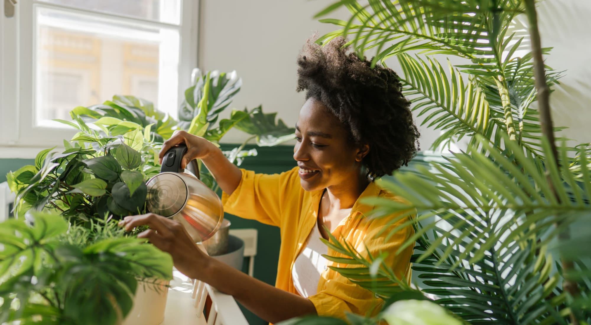 Resident watering plants in their new living room at The Alden in Pittsburgh, Pennsylvania