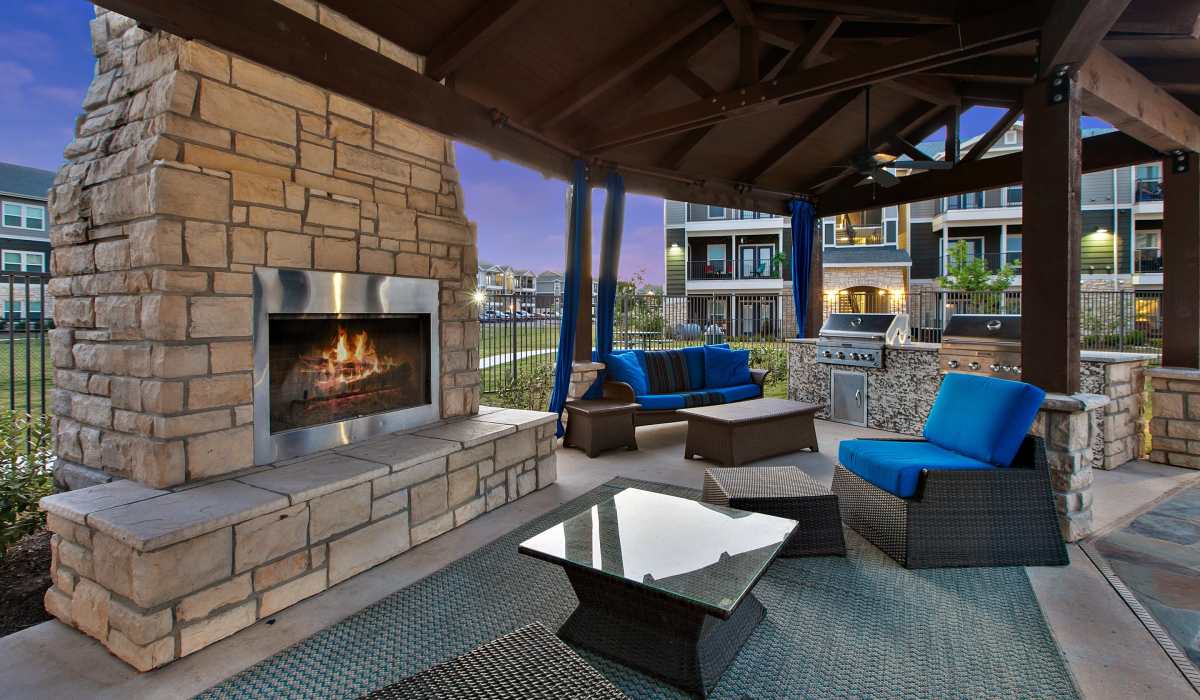Community seating with fireplace and barbeque area at Canyon House in New Braunfels, Texas