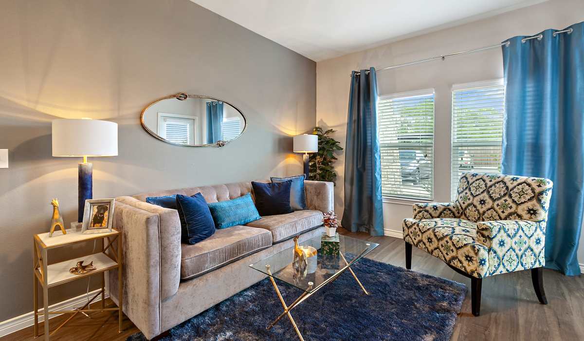 Spacious living room with couch, chair and large windows at Canyon House in New Braunfels, Texas