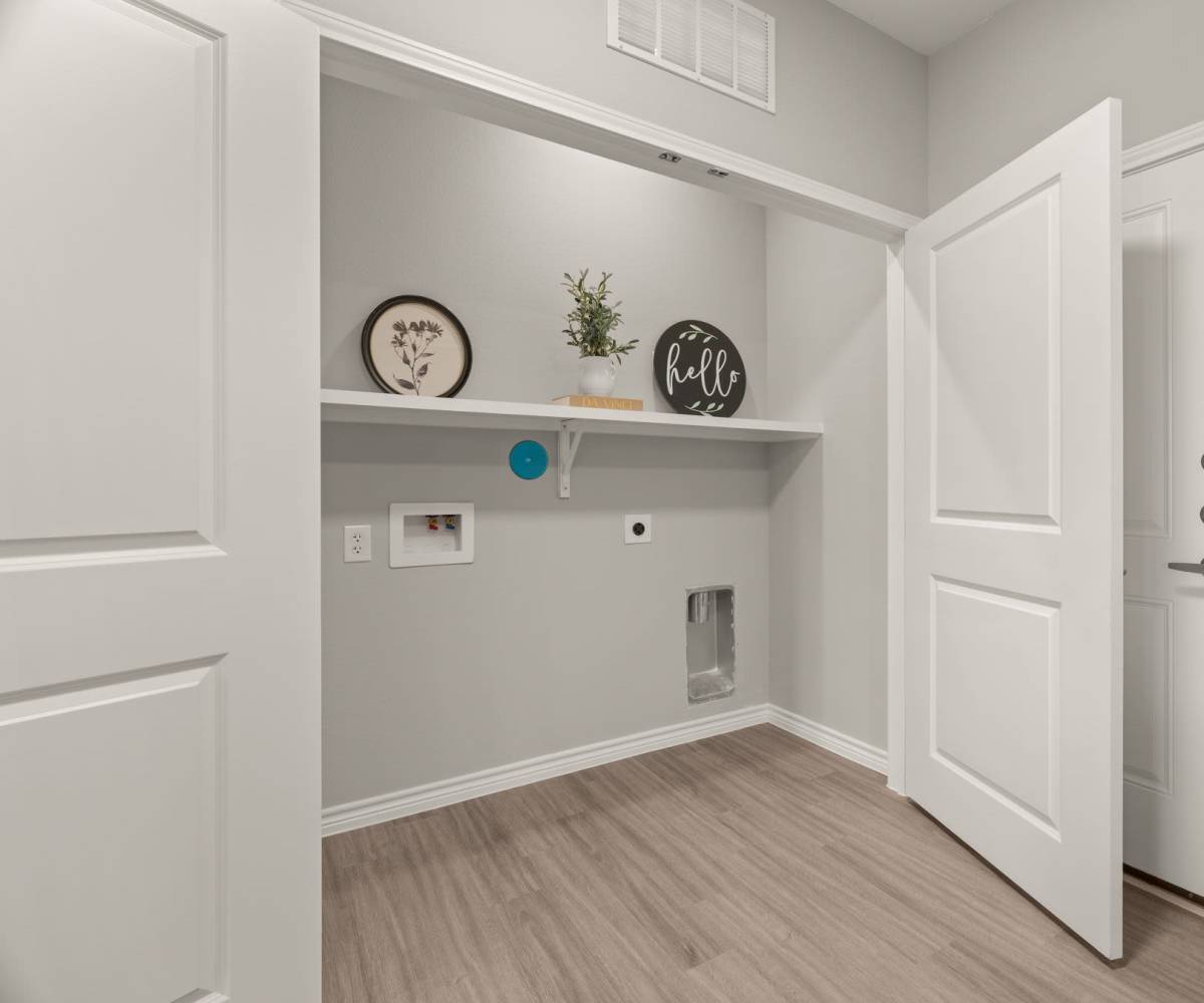 In-home laundry room with shelving at Walnut Springs in Seguin, Texas