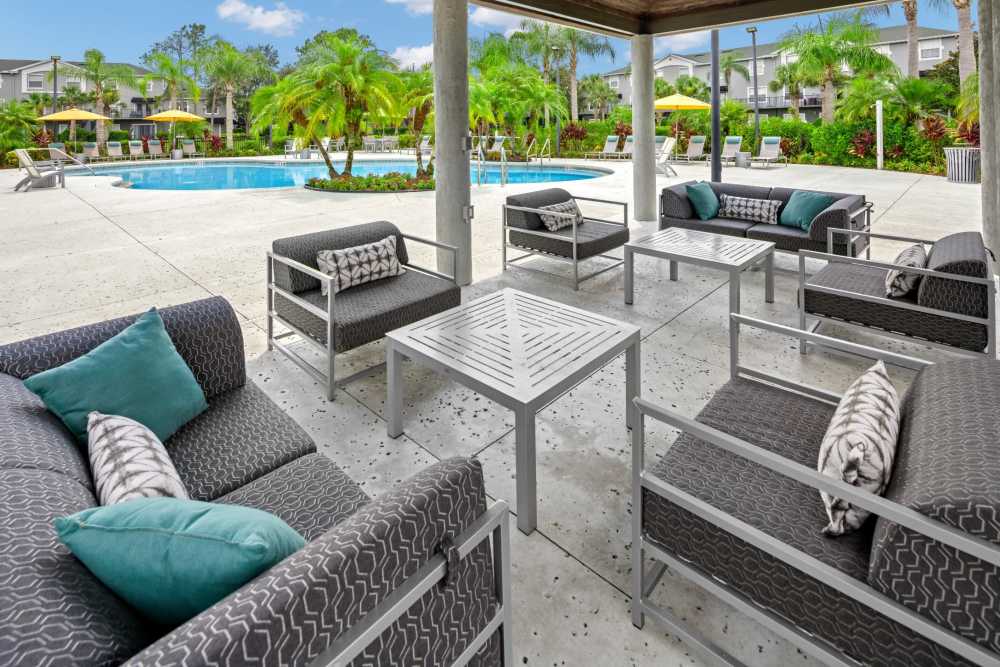 Covered patio seating near the pool at Pointe Parc at Avalon in Orlando, Florida