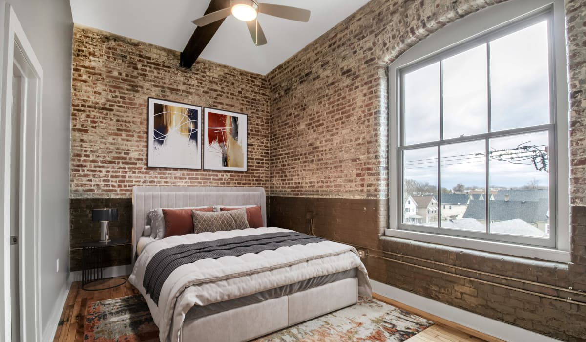 Exposed brick in a bright bedroom at Barcalo Living in Buffalo, New York