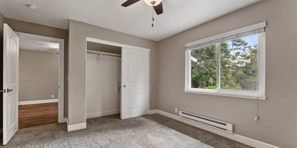 Spacious bedroom with a large closet, ceiling fan, and plush carpeting at Vista Creek Apartments in Castro Valley, California