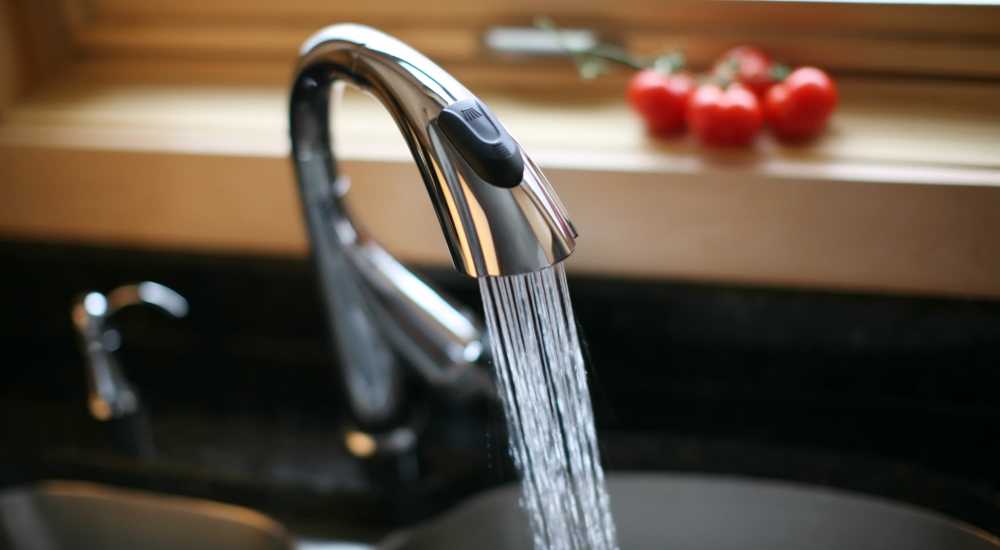 Faucet with running water and tomatoes at Atrium Gardens in Arlington, Texas 